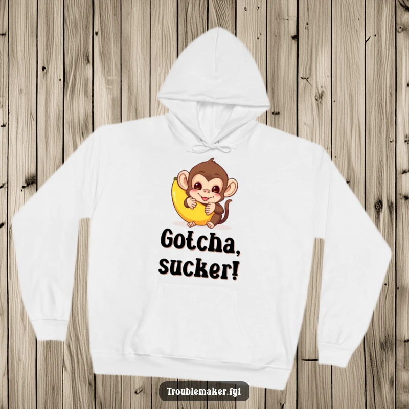 Funny hoodie design of a mischievous monkey hiding behind a banana peel, perfect for cozy, playful moments.