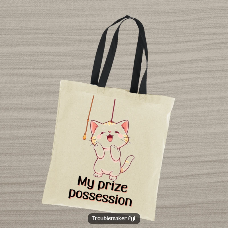 Funny tote bag showing a cat intently batting at a dangling string, perfect for carrying essentials with a playful, feline vibe.